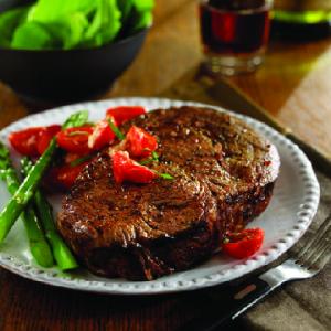 ribeye steaks with sauteed grape tomatoes and brie recipe image