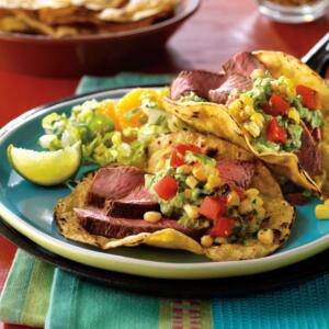 Cumin-rubbed steak tacos with spicy grilled corn salsa recipe image